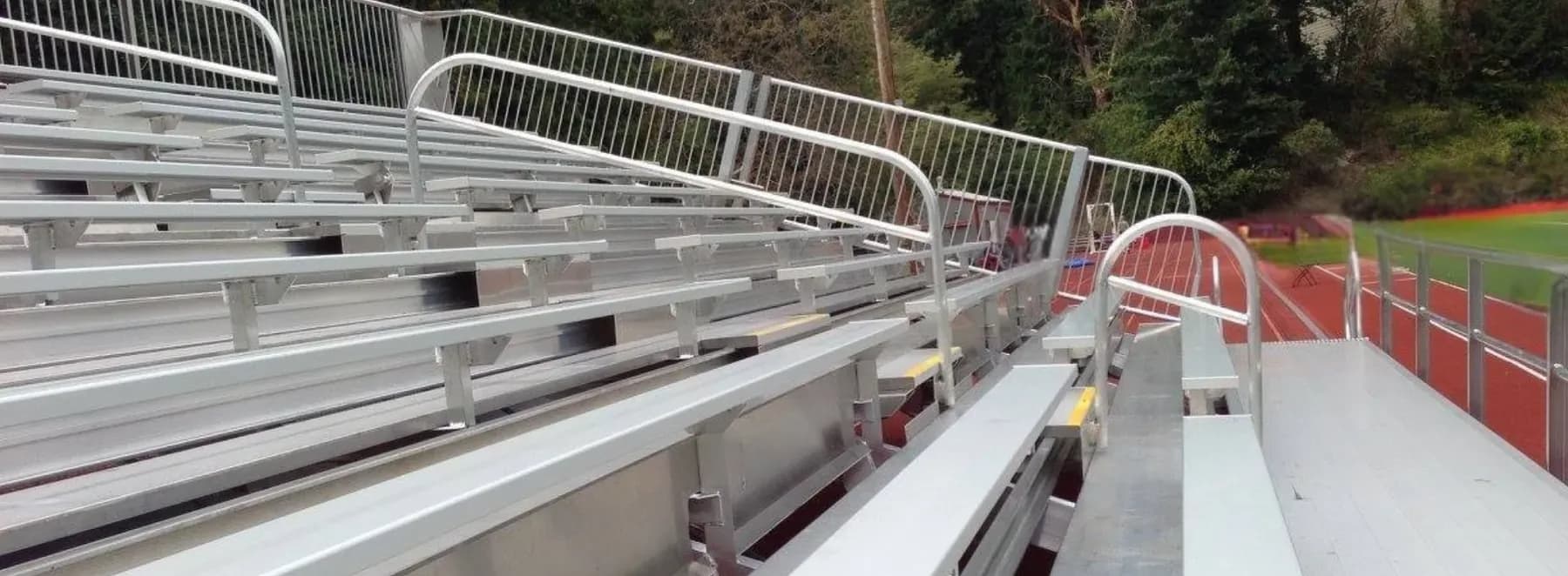 Portable aluminum bleachers set up beside a track at an outdoor Pacific Northwest venue